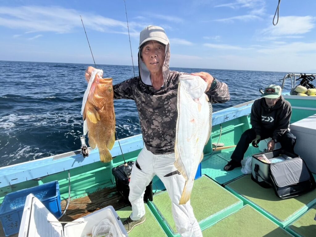 釣り上げたアコウなどを手にする釣り客。玄界灘・宗像大島沖、若潮丸の落とし込み釣り